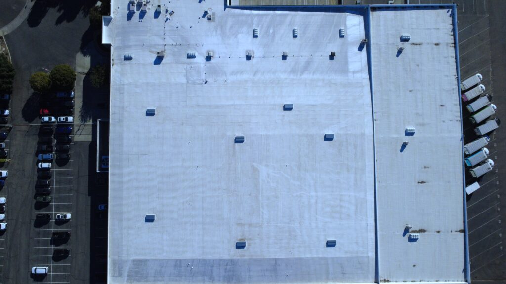 Top-down aerial of warehouse roof and parking