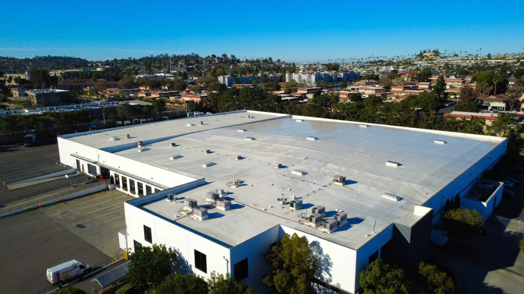 Drone perspective of white roof and neighborhood