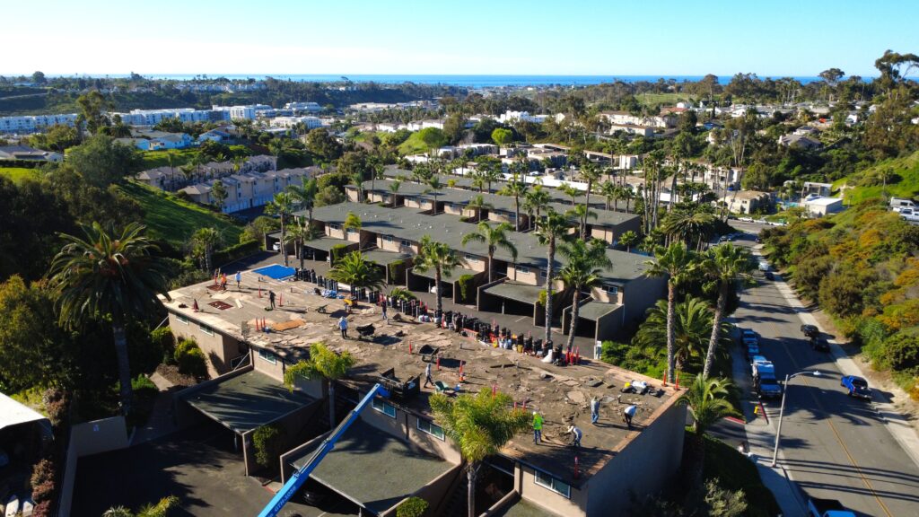 Aerial view of building roof repair and coastline