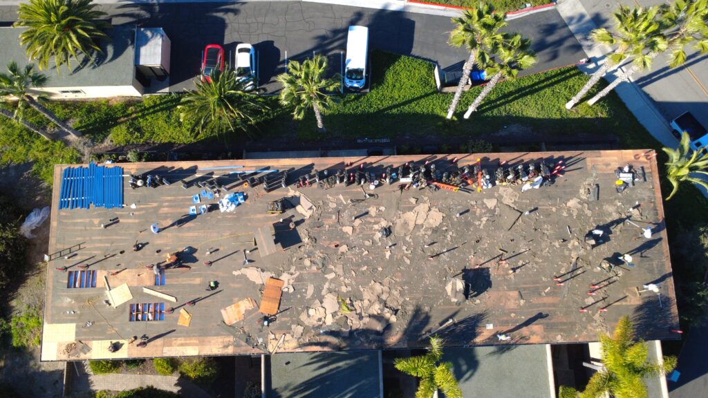 Rooftop tear-off with workers and debris