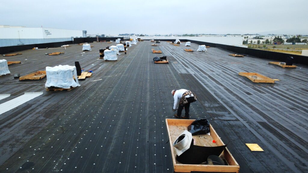 Worker installing rooftop underlayment panels